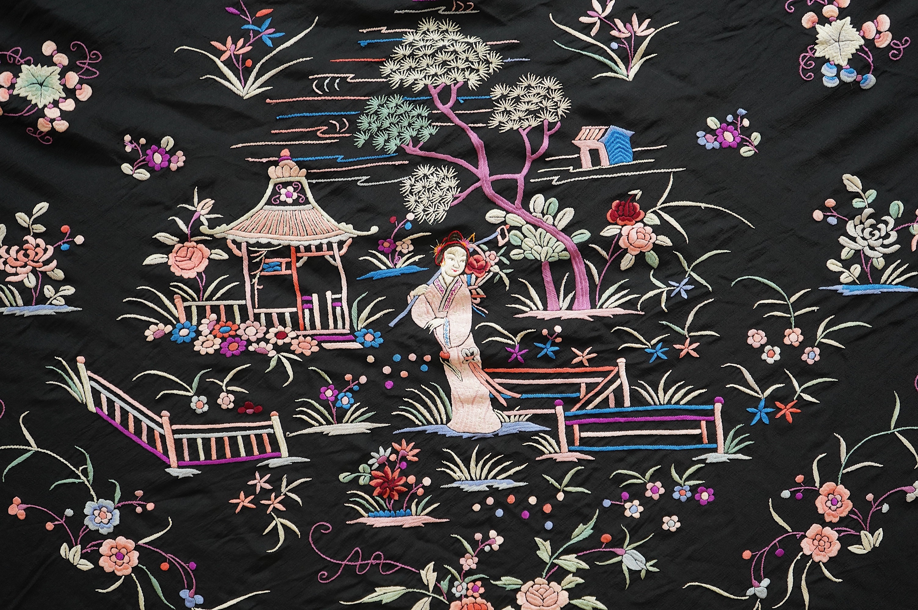 Two Chinese embroidered silk fringed shawls, one cream floral embroidery on cream silk, the other polychrome silk embroidered with figures on black silk, black shawl 130cm x 136cm, cream shawl 128cm x 168cm. Condition -